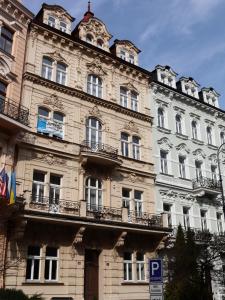 un gran edificio de piedra con balcones en un lateral. en 7k-Apartmán Sadová, en Karlovy Vary