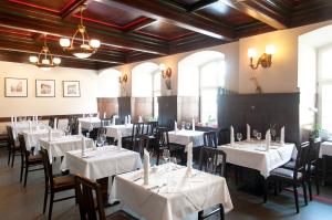 Gasthaus Alte Münze في تسفيكاو: غرفة طعام مع طاولات وكراسي بيضاء