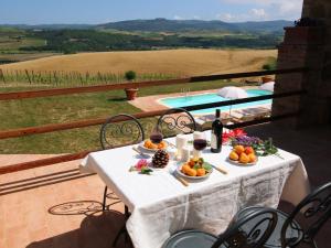 tavolo con frutta e vino e piscina di Belvilla by OYO Era una Volta a Montenero