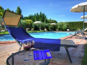 a glass of wine on a table next to a pool at Belvilla by OYO Cipresso in Cortona