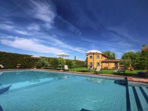 a large swimming pool in front of a house at Belvilla by OYO Cipresso in Cortona
