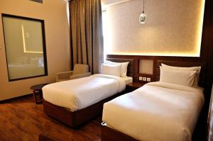 Een bed of bedden in een kamer bij Pristine Hotel, Varanasi