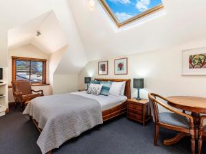 a bedroom with a bed and a desk and a table at Central Starboard in Port Fairy