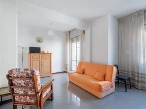 salon z pomarańczową kanapą i krzesłem w obiekcie Belvilla by OYO Apartment in Fano w mieście Fano