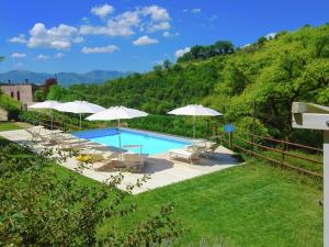 ファブリアーノにあるModern Villa with Private Pool in Fabriano Italyの白いパラソルと椅子付きのスイミングプール