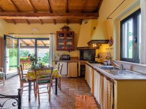 eine Küche mit einem Tisch und eine Küche mit gelben Wänden in der Unterkunft Belvilla by OYO La Cinciallegra in Acqualagna
