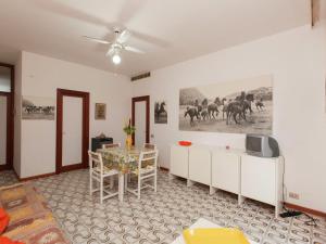 salon ze stołem i telewizorem w obiekcie Belvilla by OYO Il Girasole w mieście Principina a Mare