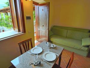 stół jadalny z 2 krzesłami i kanapą w obiekcie Luxurious Mansion in Parghelia near Sea w mieście Parghelia
