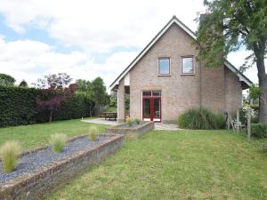 a brick house with a lawn in front of it at Beautiful Holiday Home in Eede with Garden in Eede