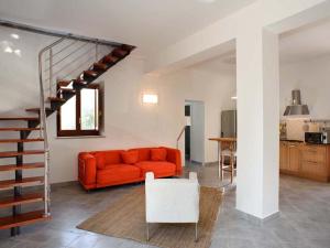 パッティにあるBelvilla by OYO Casa Ciceroのリビングルーム(オレンジ色のソファ、階段付)