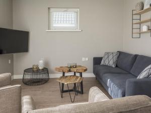 a living room with a couch and a table at Modern Bungalow in De Cocksdorp with Terrace in De Cocksdorp