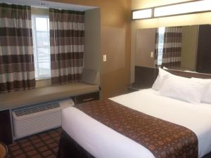 a hotel room with a bed and a window at Microtel Inn & Suites-Sayre, PA in Sayre