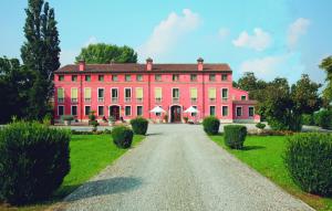 a large red house with a road in front of it at Hotel Villa Montanarini in Villarotta
