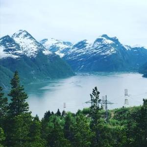 uma vista para um lago com montanhas cobertas de neve em Sunndalsøra Hotell em Sunndalsøra