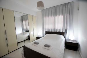 a bedroom with a white bed and a mirror at Glabur Stays - The Fabulous 2 BDR - Nicosia City, Free Parking & Wifi, Welcomes You!!! in Nicosia