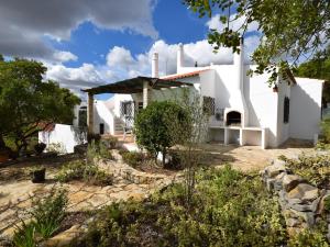 una casa blanca con un jardín delante de ella en Secluded villa with a private swimming pool, en Santa Bárbara de Nexe