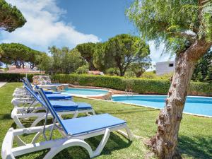 a row of lounge chairs next to a swimming pool at Wonderful villa in Vilamoura with barbecue and private swimming pool in Vilamoura