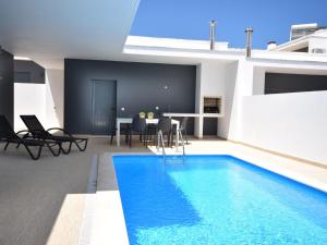 a swimming pool in the middle of a house at Modern villa with private pool near the beautiful beach of Foz de Arelho in Nadadouro