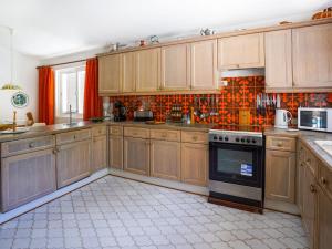 cocina con armarios de madera y horno con fogones en Roofed Villa in Albufeira with Private Swimming Pool en Olhos de Água