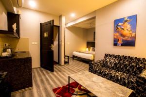 パナジにあるEncore Suites Goaのリビングルーム(ソファ、ベッド付)