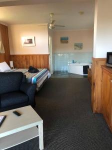 a hotel room with a bed and a bath tub at Seaview Norfolk Island in Burnt Pine
