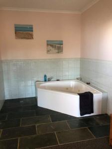 a white bath tub in a bathroom with tiles at Seaview Norfolk Island in Burnt Pine