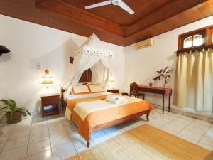 a bedroom with a large bed with a canopy at Binaria Museum Hotel in Lovina