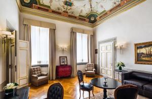 
a living room filled with furniture and a large window at Relais Santa Croce, By Baglioni Hotels in Florence
