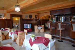 a restaurant with tables and chairs and a television at Hotel Schwarzer Bär in Zittau