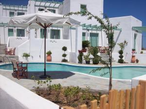 - une piscine avec un parasol, une table et des chaises dans l'établissement Skyros Seaside Retreats - Serenity by the Pool, à Skiros