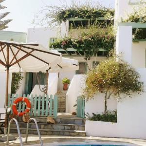 une terrasse avec un parasol et des chaises à côté d'un bâtiment dans l'établissement Skyros Seaside Retreats - Serenity by the Pool, à Skiros