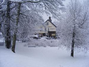 a snow covered yard with a house in the background at Beechwood in Bowness-on-Windermere