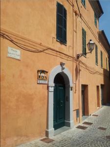 Serra San QuiricoにあるB&B Il Colleの緑の扉のあるオレンジ色の建物
