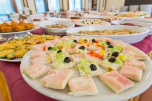 einen Tisch mit Teller mit Lebensmitteln auf einem Tisch in der Unterkunft Hotel Splendid in Gatteo a Mare