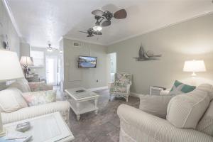 ein Wohnzimmer mit weißen Möbeln und einem Deckenventilator in der Unterkunft Clearwater Beach Suites 105 condo in Clearwater Beach
