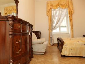 1 dormitorio con vestidor, cama y silla en 7k-Apartmán Sadová, en Karlovy Vary