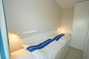 Habitación con cama con sábanas azules y blancas. en Seepark Seepark 3f, en Heiligenhafen