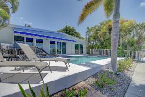 a house with chairs and a swimming pool at Water Lover's Paradise - Weekly Rental home in Clearwater Beach