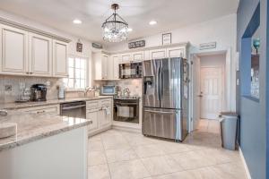 a kitchen with white cabinets and a stainless steel refrigerator at Water Lover's Paradise - Weekly Rental home in Clearwater Beach