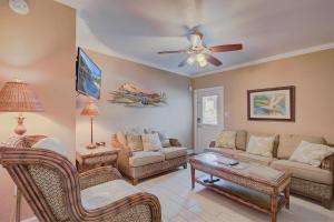 a living room with a couch and a ceiling fan at Clearwater Beach Suites 102 condo in Clearwater Beach