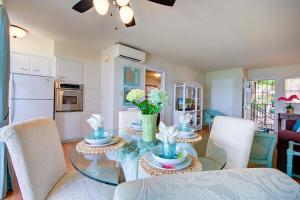 a dining room with a glass table and white chairs at Bay Watch apts in Clearwater Beach