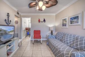 a living room with a couch and a tv at Clearwater Beach Suites 201 condo in Clearwater Beach