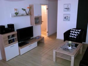 ein Wohnzimmer mit Fernseher und Tisch in der Unterkunft Ferienpark L10-008 Ferienpark in Heiligenhafen