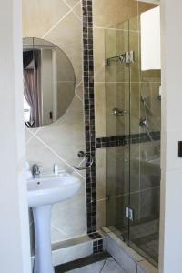a bathroom with a sink and a shower at At Doms B&B in Ballito