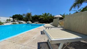 - une piscine avec 2 chaises et un parasol dans l'établissement La Chiesura, à Galugnano