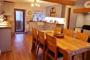 a kitchen and dining room with a wooden table and chairs at Rosedale Cottage in Rosedale Abbey