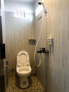 een badkamer met een toilet en een douche bij Bamboe Inn 2 Homestay in Tanjungkarang