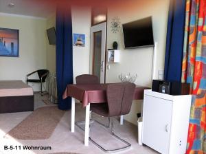 Kleines Zimmer mit einem Tisch und einem TV. in der Unterkunft Ferienpark B05-011 Ferienpark in Heiligenhafen + 4 Fotos