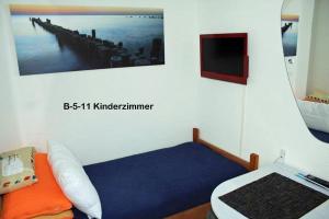 Zimmer mit einem Bett und einem Bild von einem Pier in der Unterkunft Ferienpark B05-011 Ferienpark in Heiligenhafen
