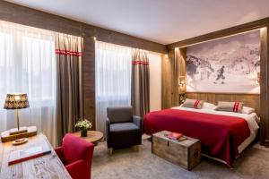 um quarto de hotel com uma cama vermelha e uma cadeira em Edelweiss Manotel em Genebra